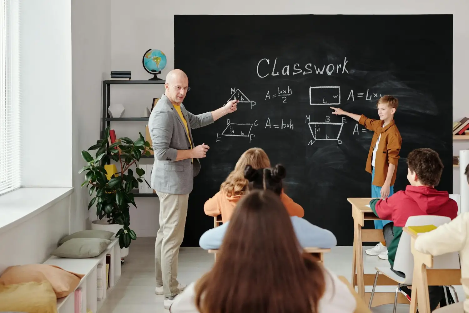 Math teacher and student engaging in mathematics on a blackboard