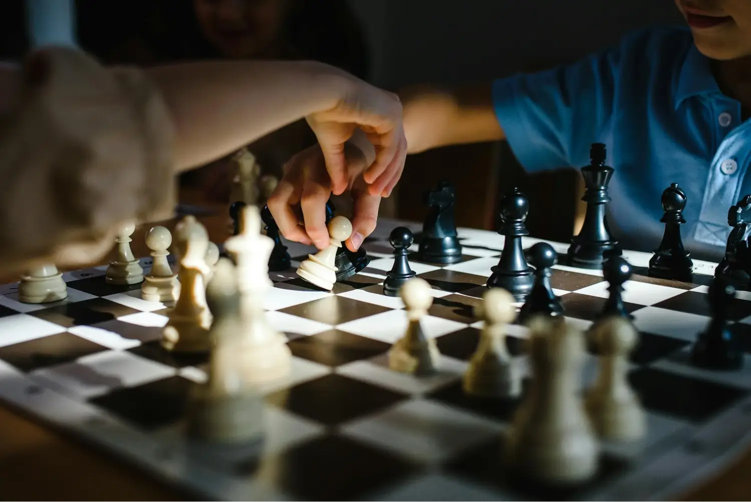 Child's hands moving chess pieces