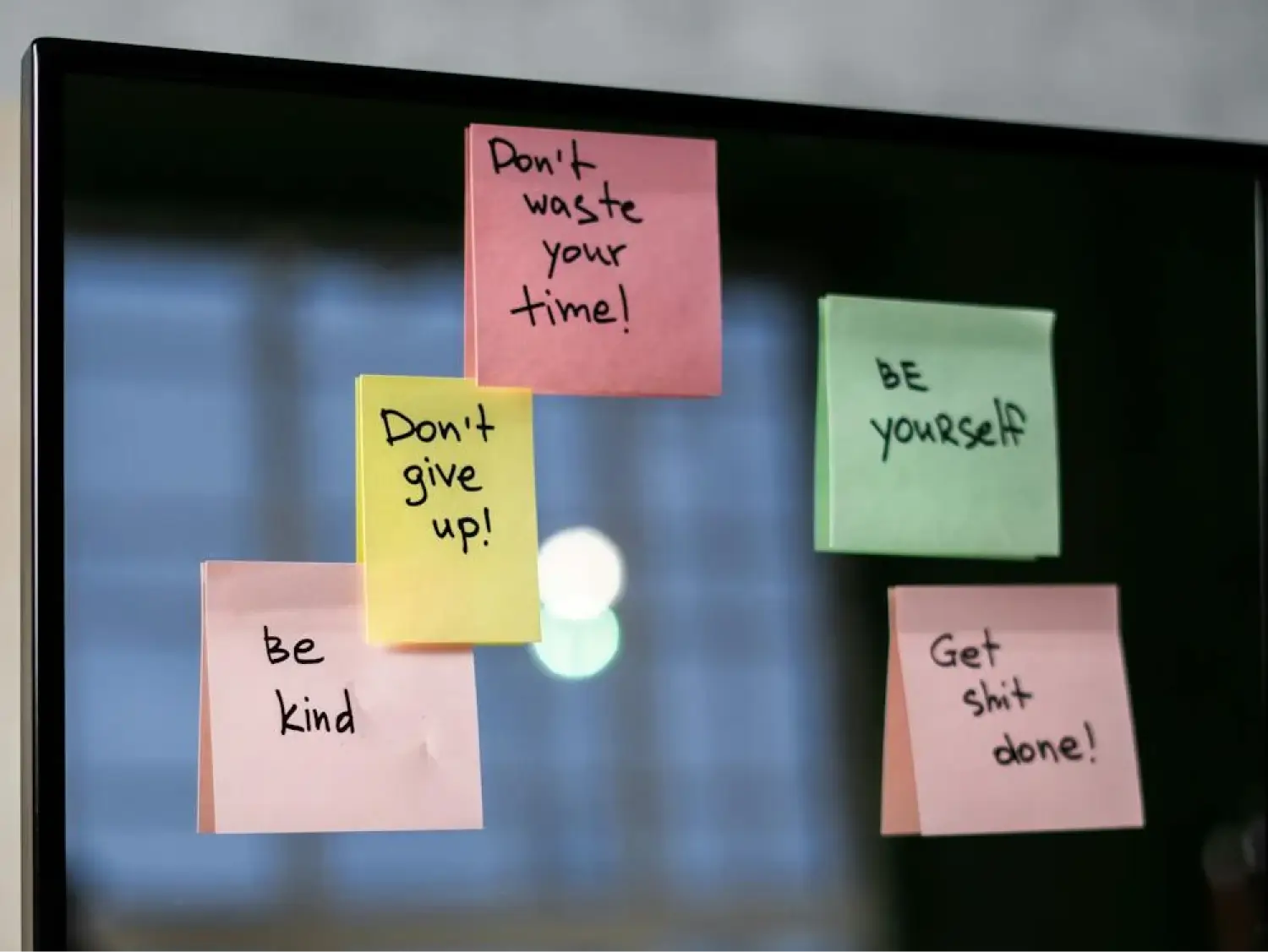 Sticky notes with motivational messages on a monitor